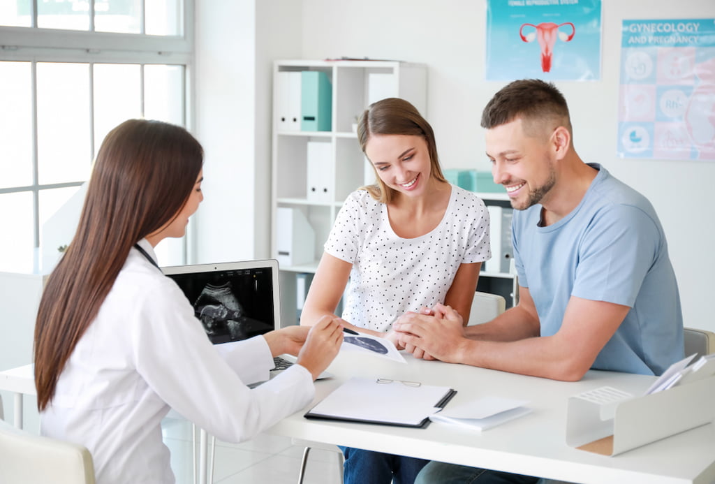 Couple consulting a doctor about healthy FSH levels for pregnancy.