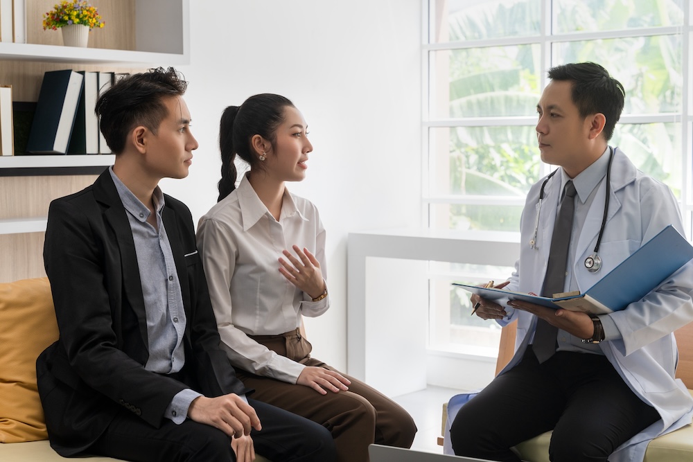 A young couple consulting with a doctor.